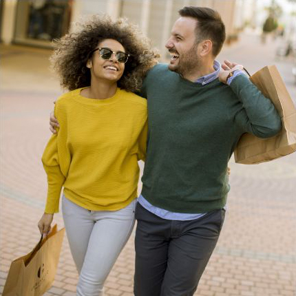 couple walking down the street with brown shopping bags
